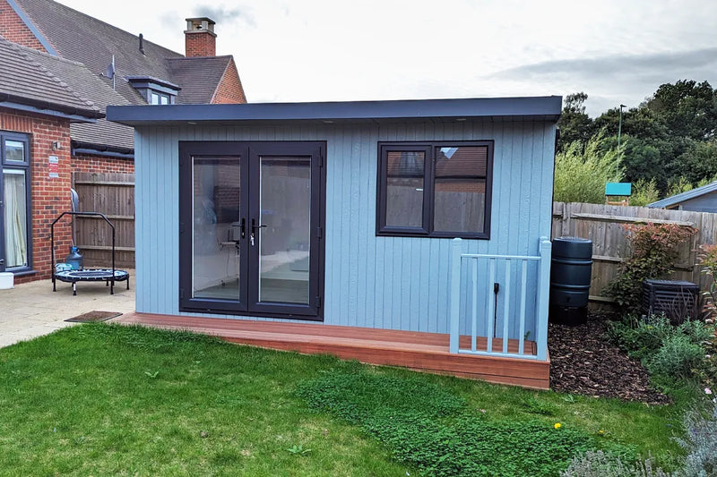 PentHaus garden room in light blue cladding with grey French doors and composite decking