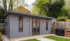 Suresheds Kingsdale Contemporary composite garden room in a landscaped garden, grey composite cladding with anthracite trims